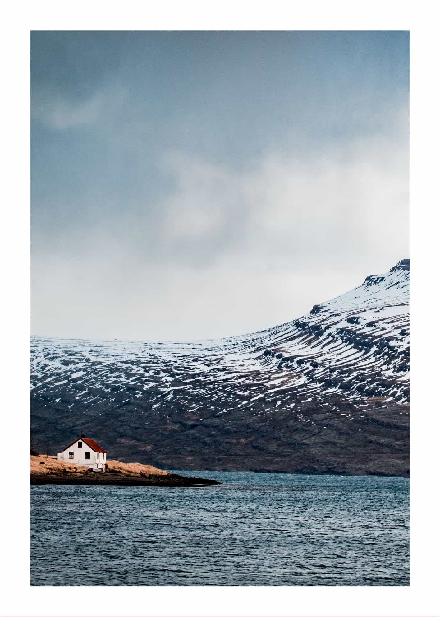 Ensamt hus bland snöiga berg poster